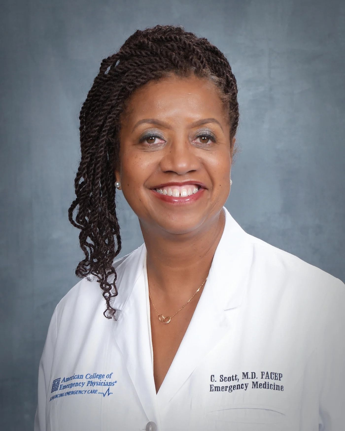Dr. Carol J. Scott in a white coat, smiling.